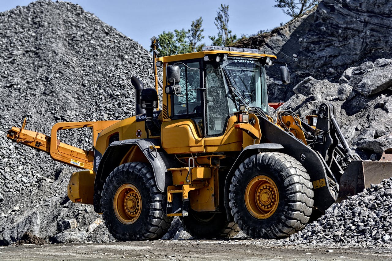 cta-image Powerful yellow construction loader moving gravel in an industrial quarry site.